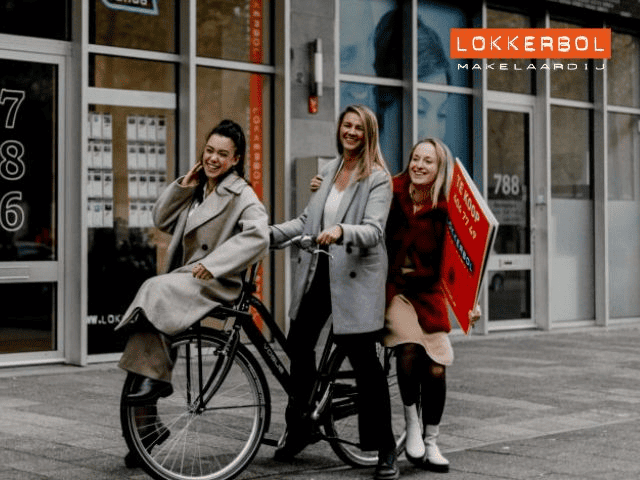 3 lachende dames op een fiets.